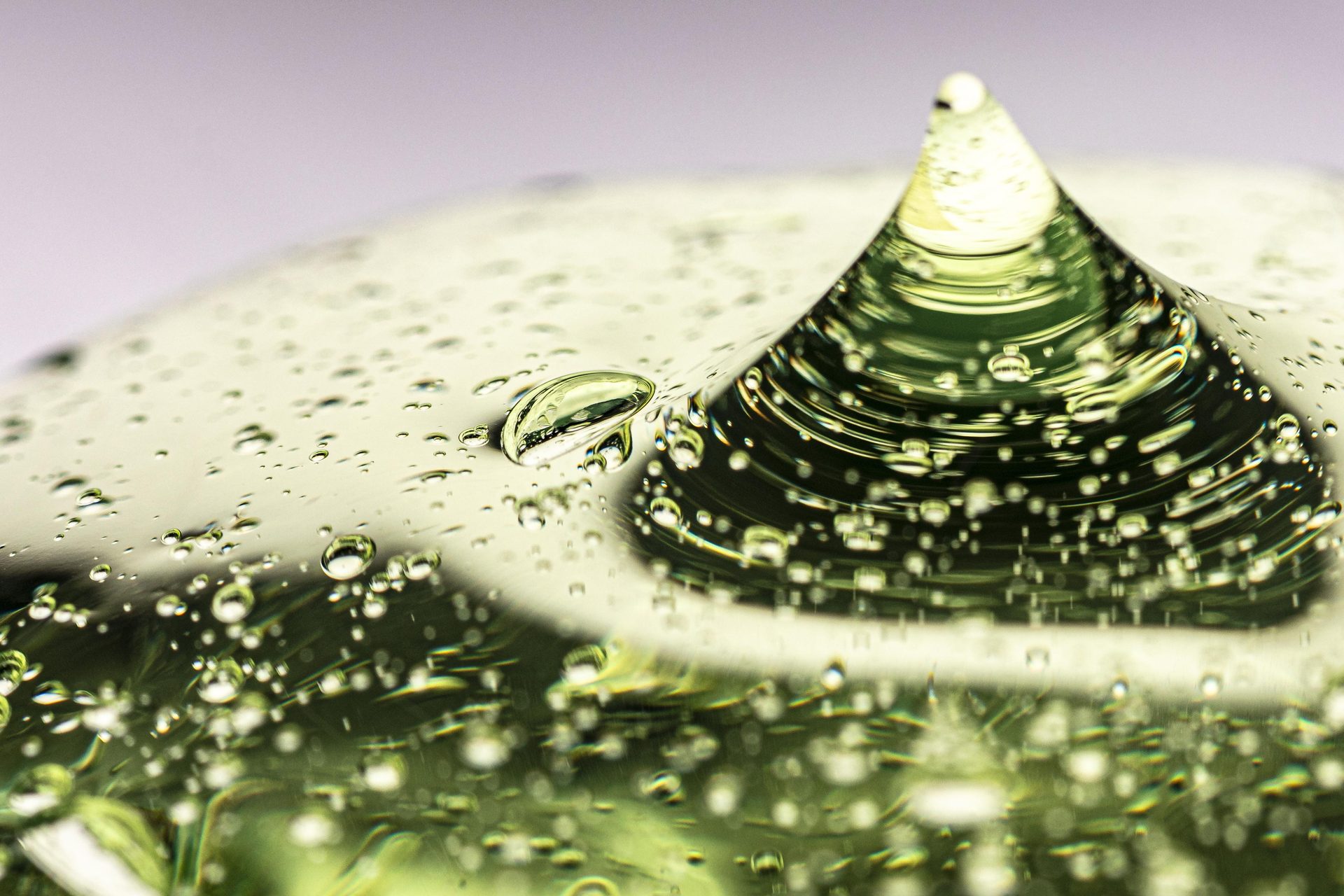 Gel transparente verde pálido que se eleva en un pico, lleno de diminutas burbujas, en primer plano